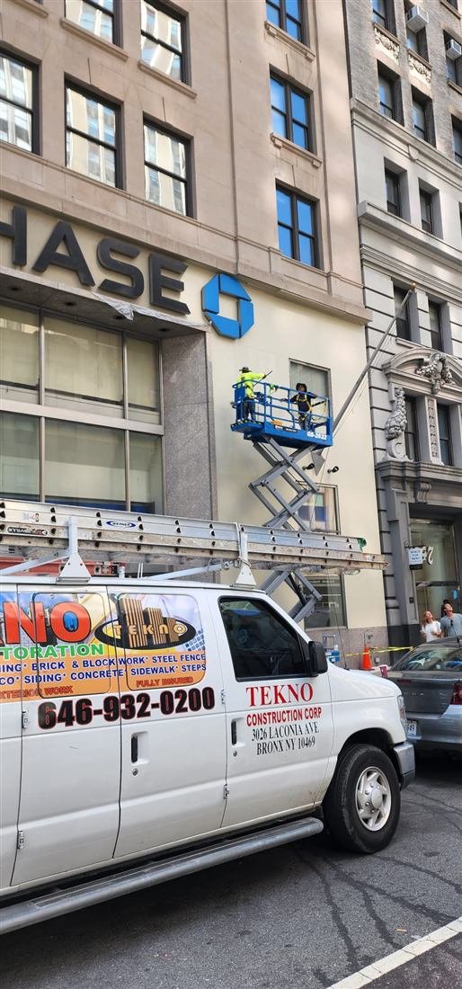Tekno Construction crew on a scissor lift performing facade restoration work at a Chase bank branch in Manhattan