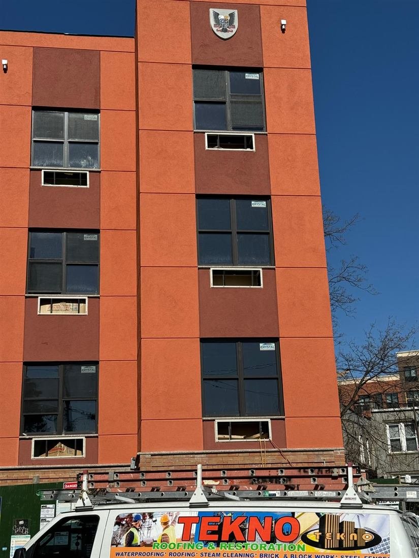 Multi-story building facade with newly installed windows after exterior restoration by Tekno Construction in New York