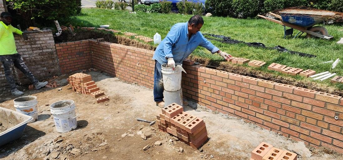 Tekno Construction mason repointing brick mortar joints before waterproof sealing on an NYC facade