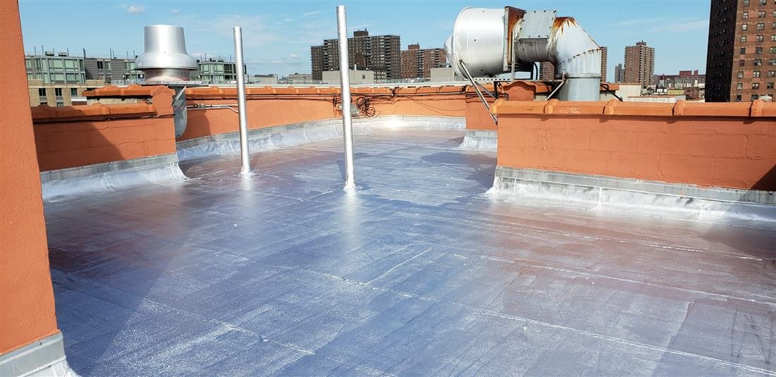 Completed aluminum-coated flat roof with restored parapet walls by Tekno Construction