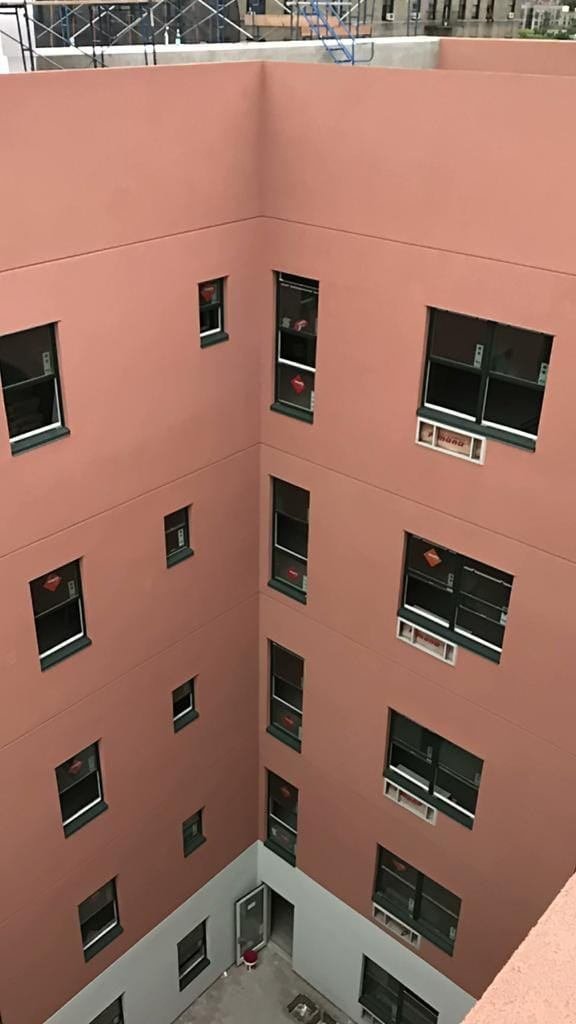 Freshly applied stucco on a residential building courtyard facade completed by Tekno Construction in New York