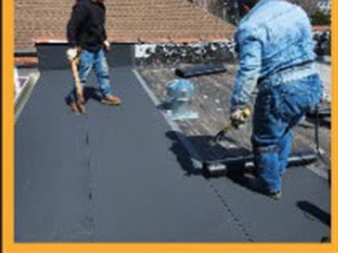 Tekno Construction crew installing a flat torch-down roof